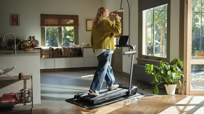 Frau geht auf dem Moov Walk Walking Pad in einer Küche